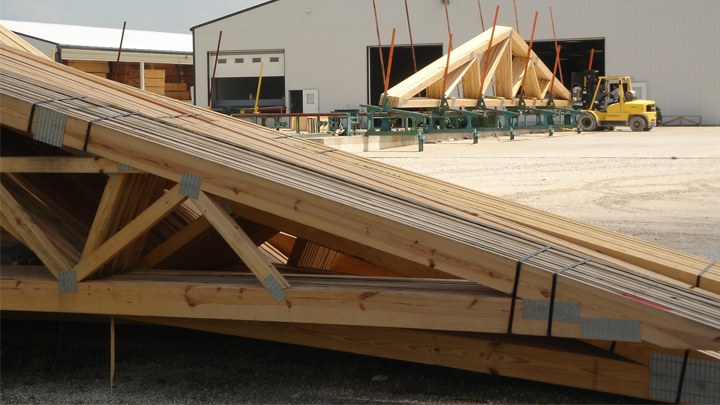 Engineered wood roof trusses stacked at the truss plant ready for delivery