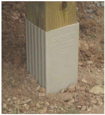 Post Protector sleeve installed around the base of a column at the ground line